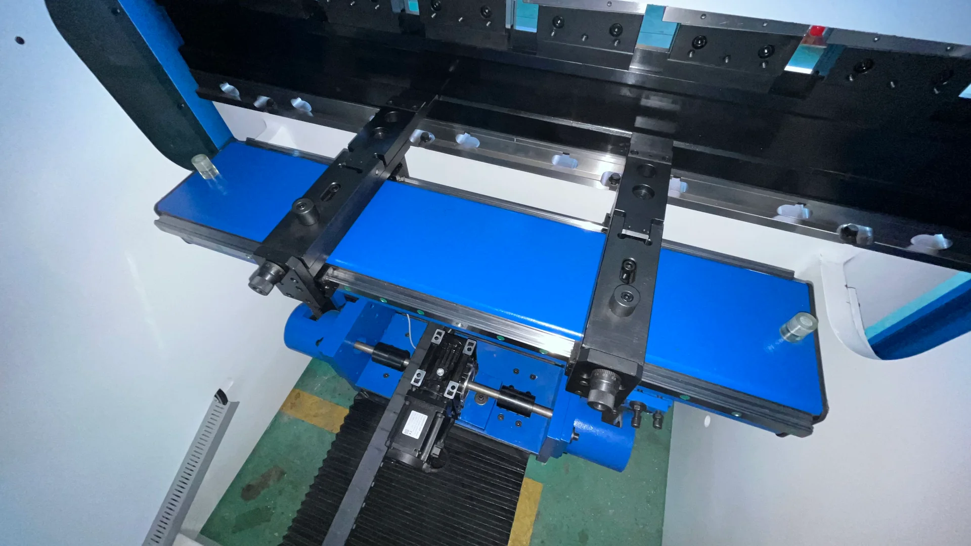 Backgauge fingers and guide rails inside a compact electric press brake.