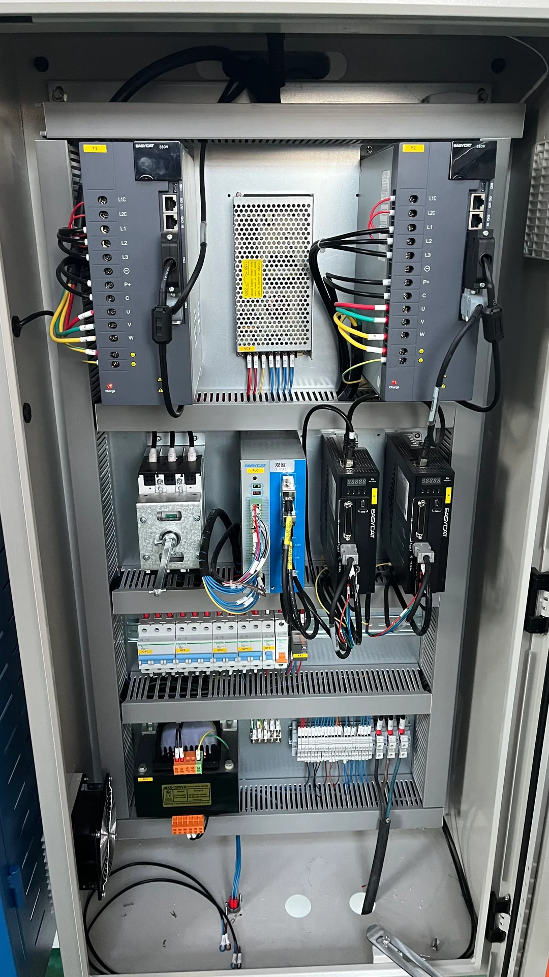 Electrical cabinet with paired drive units inside an electric press brake.