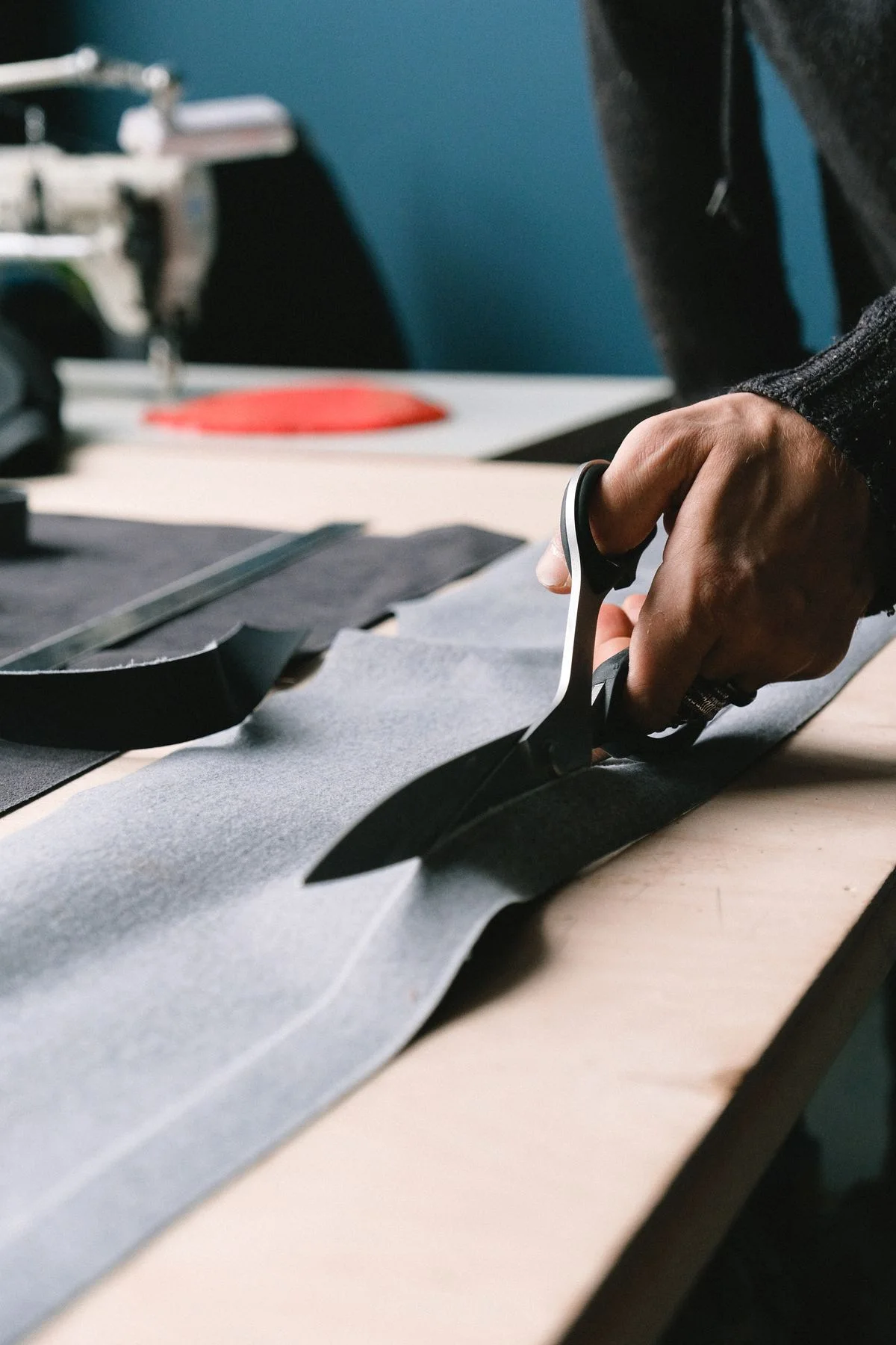Hand cutting flexible pattern material with scissors; industry illustration