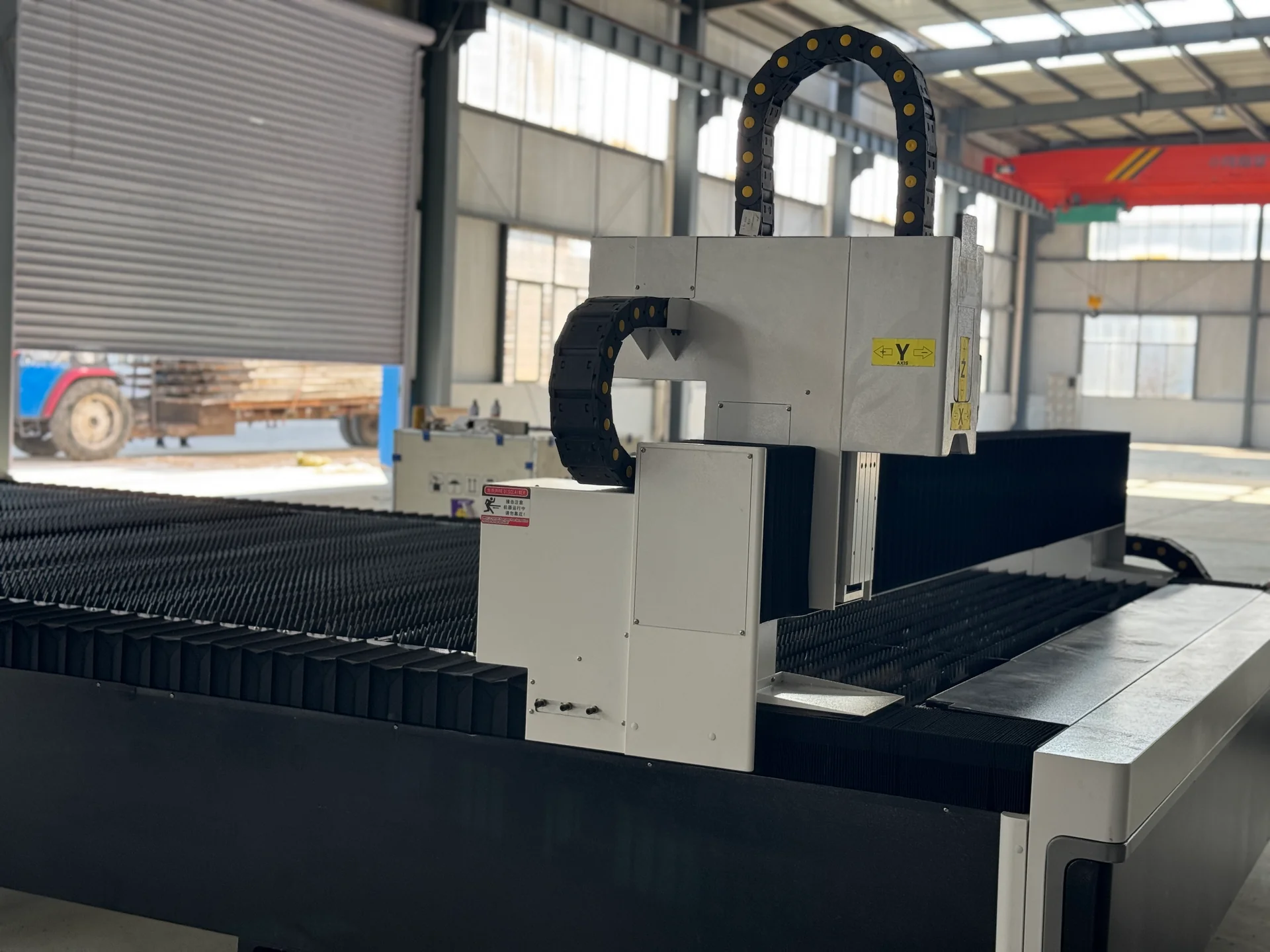 Laser machine gantry carriage with bellows covers and cable chains