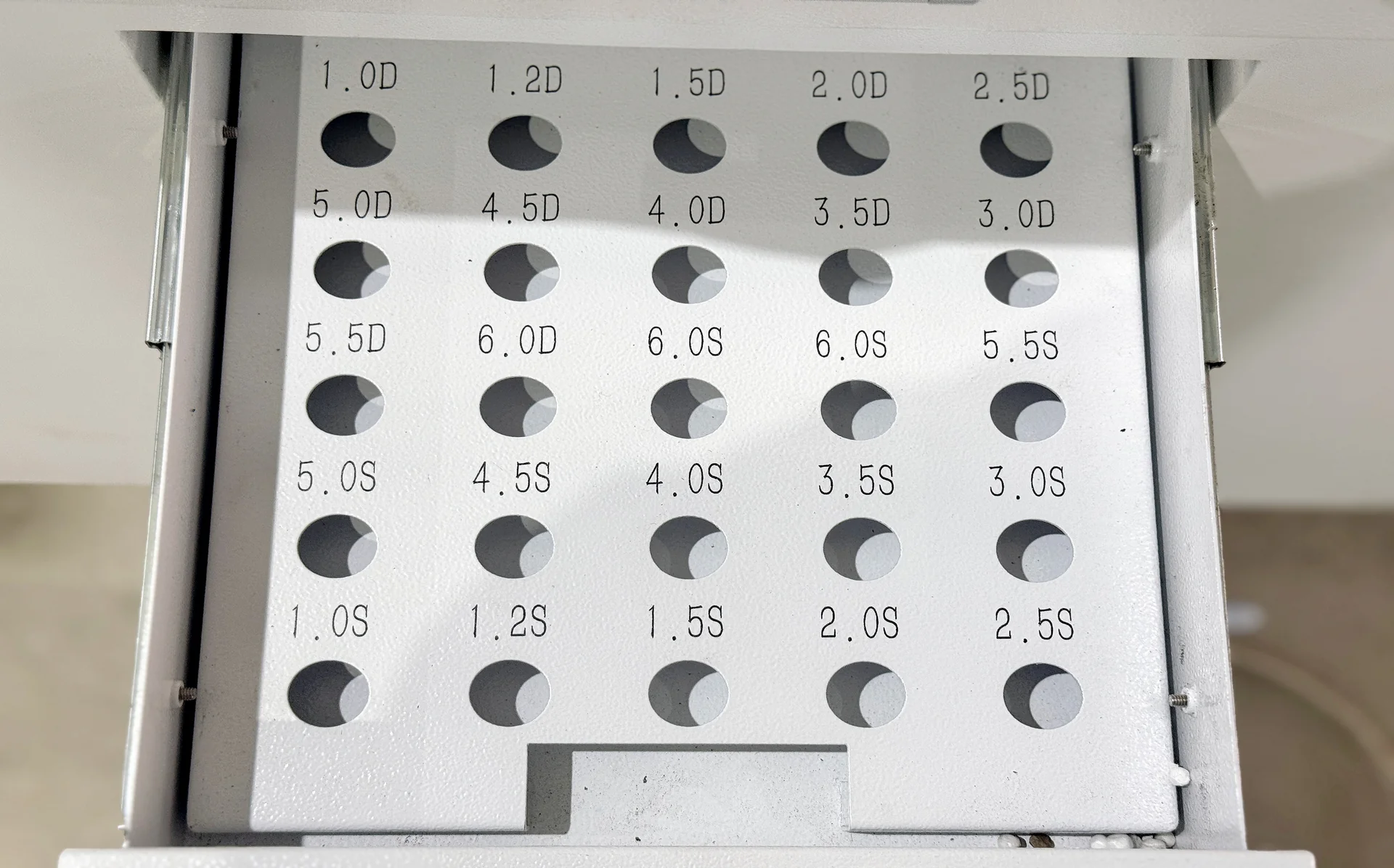 Labeled storage tray with positions for different laser nozzles