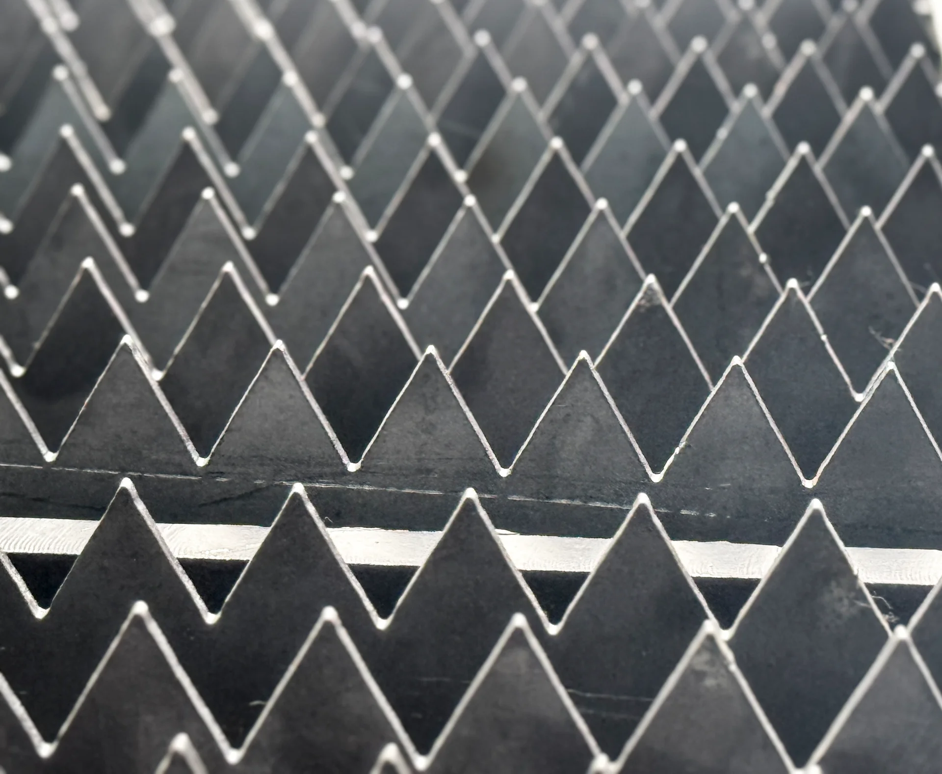 Close-up of interlocking serrated support slats on a laser cutting table