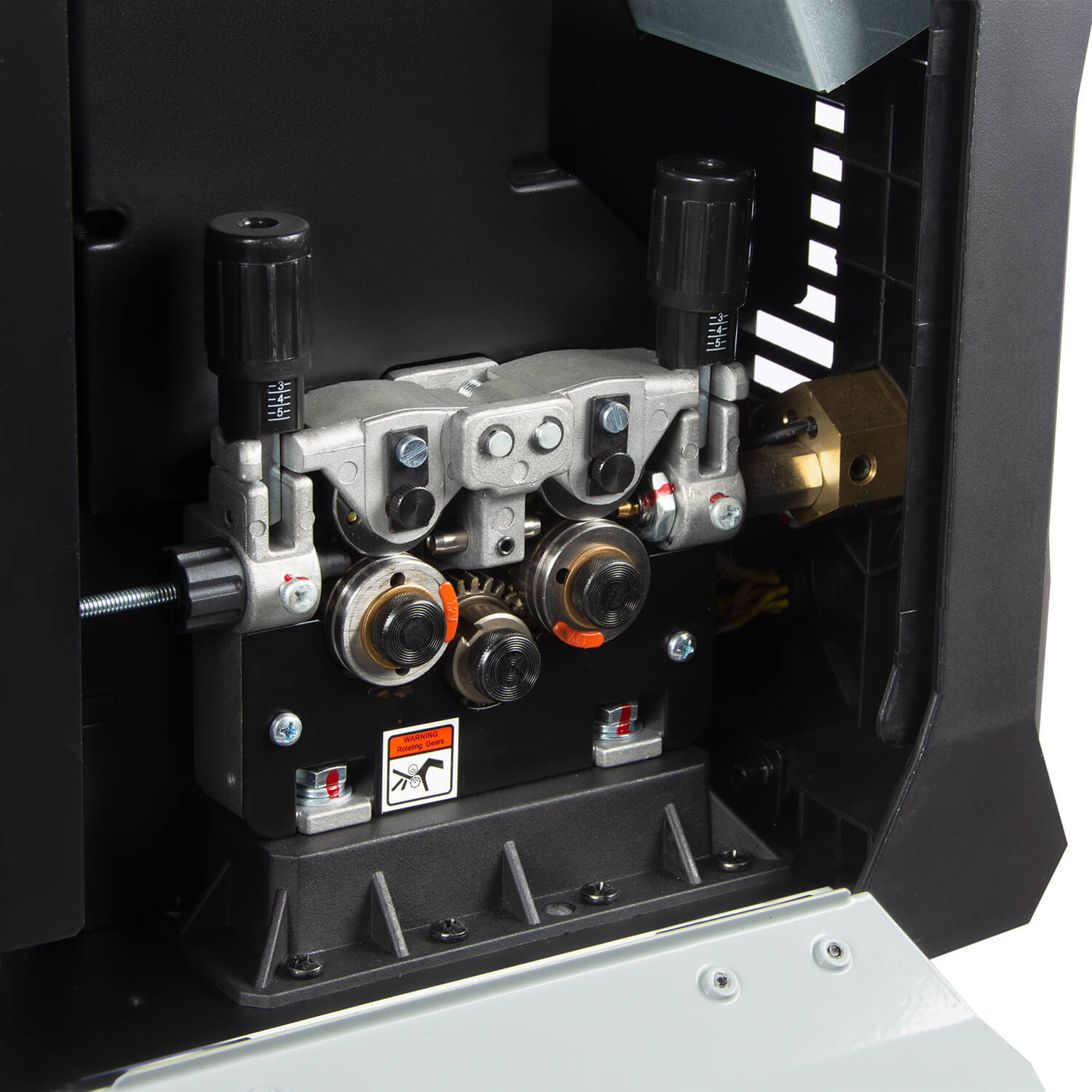 Third-party photograph of a MIG/MAG welding wire-feed mechanism with drive rolls and pressure-adjustment knobs