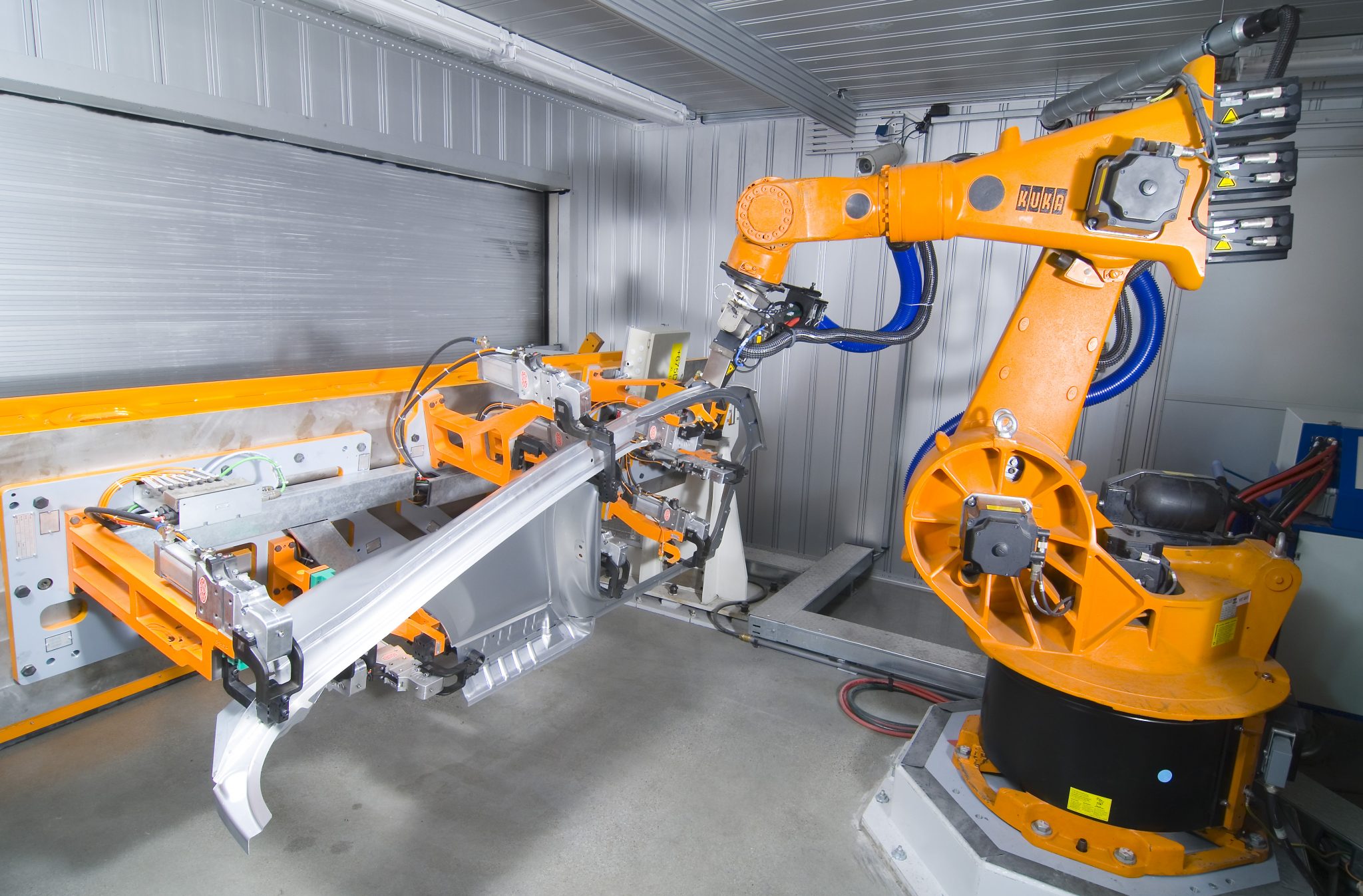 KUKA robot with laser-cleaning optics treating an automotive component in a cleanLASER cell