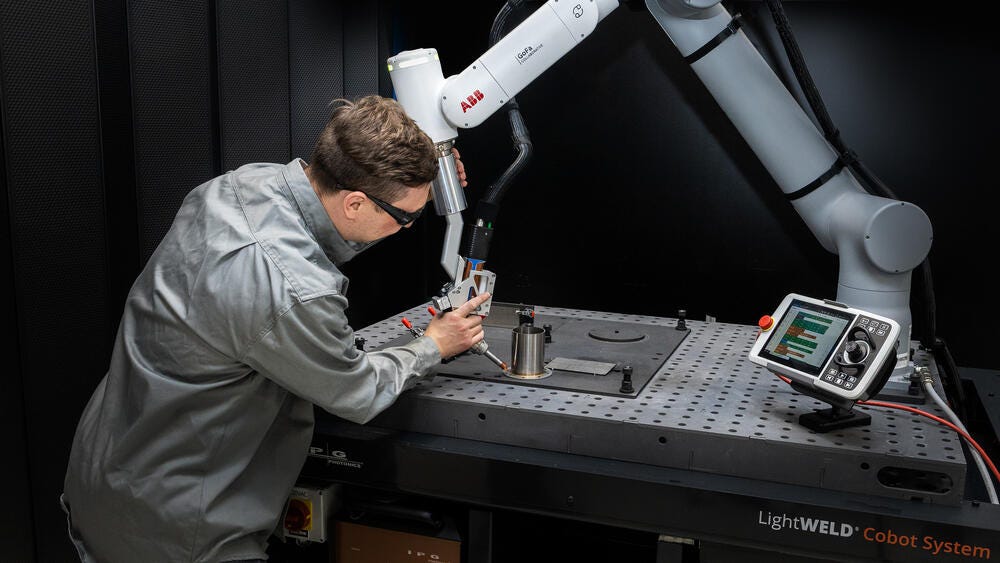 Operator teaching an IPG LightWELD laser-welding cobot path on a fixture table