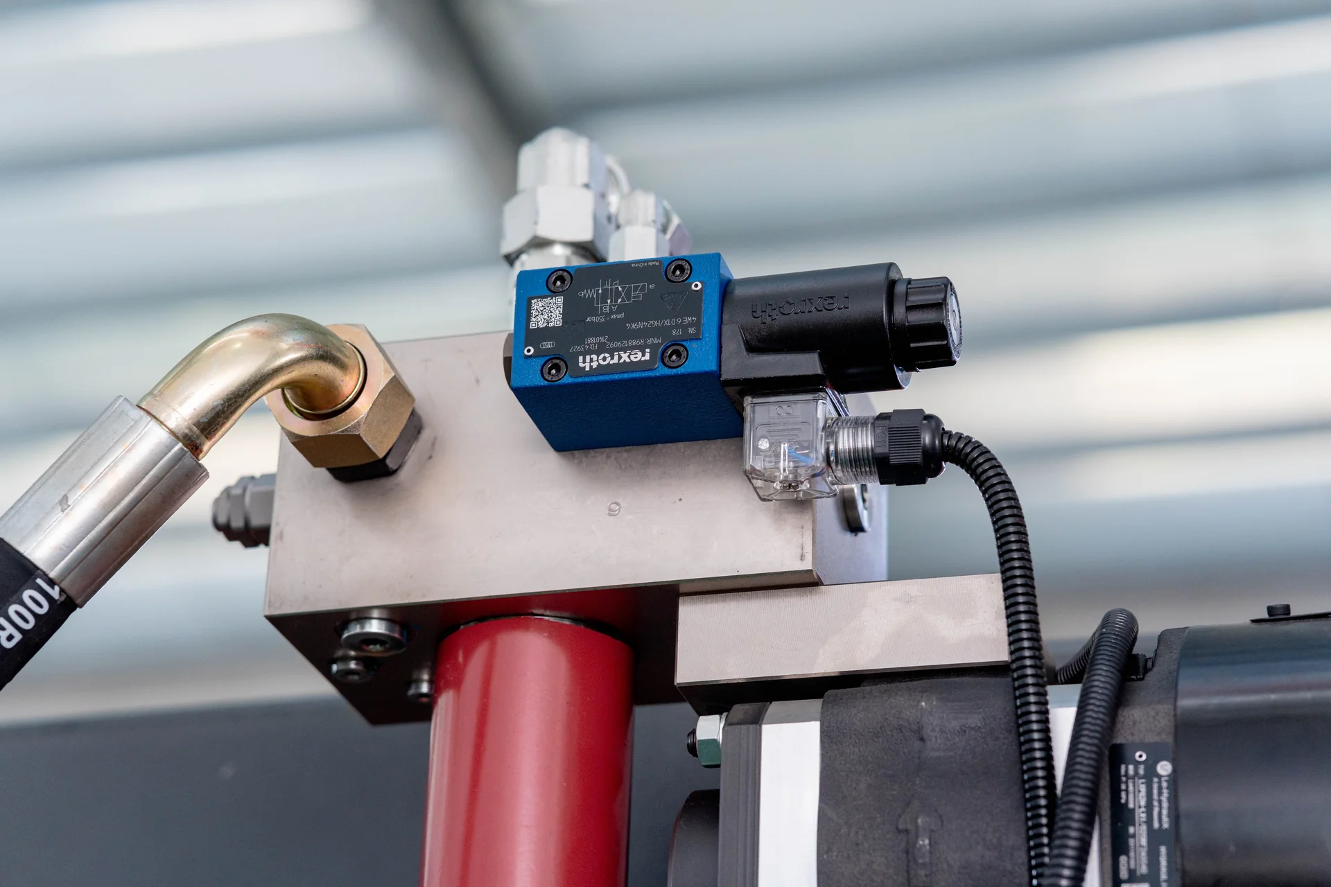 Close-up of a Rexroth hydraulic valve assembly on a press brake.