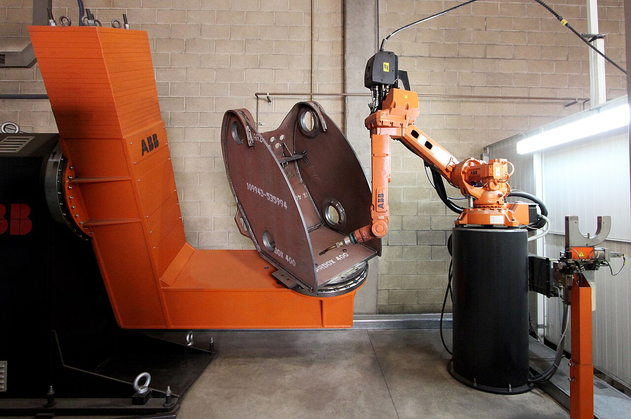 ABB welding robot and positioner holding a heavy fabricated steel housing
